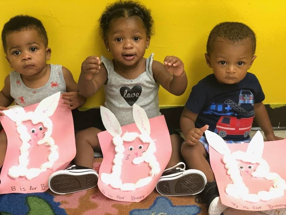 Three children sitting with bunny crafts