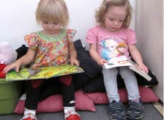 Two children sitting and reading books