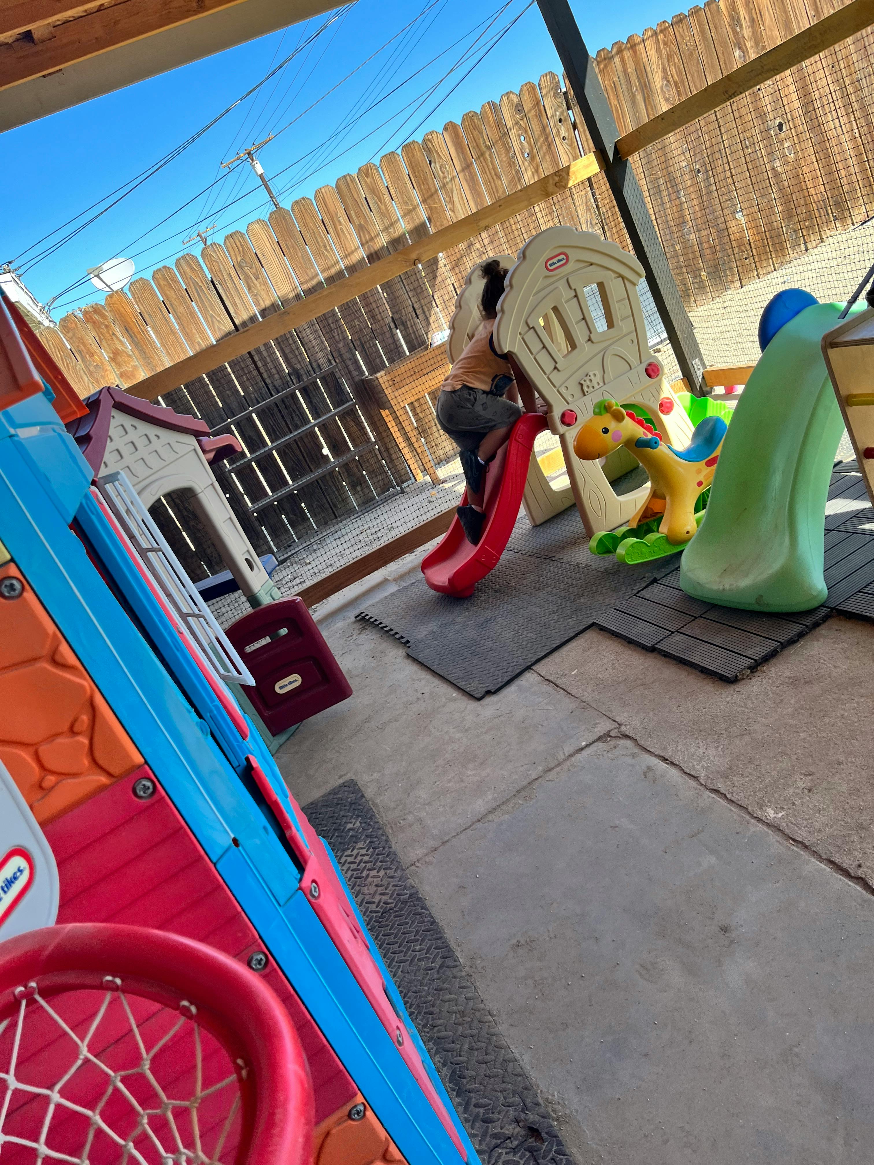 Child on a red slide in a play area