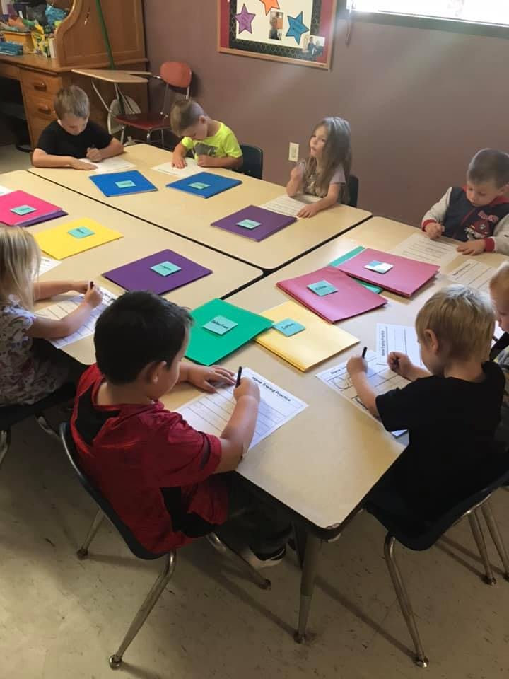 Children sitting at tables and writing