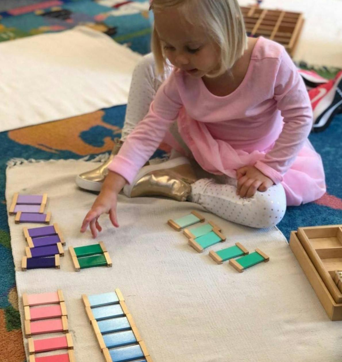 Child playing with colorful wooden blocks on a mat