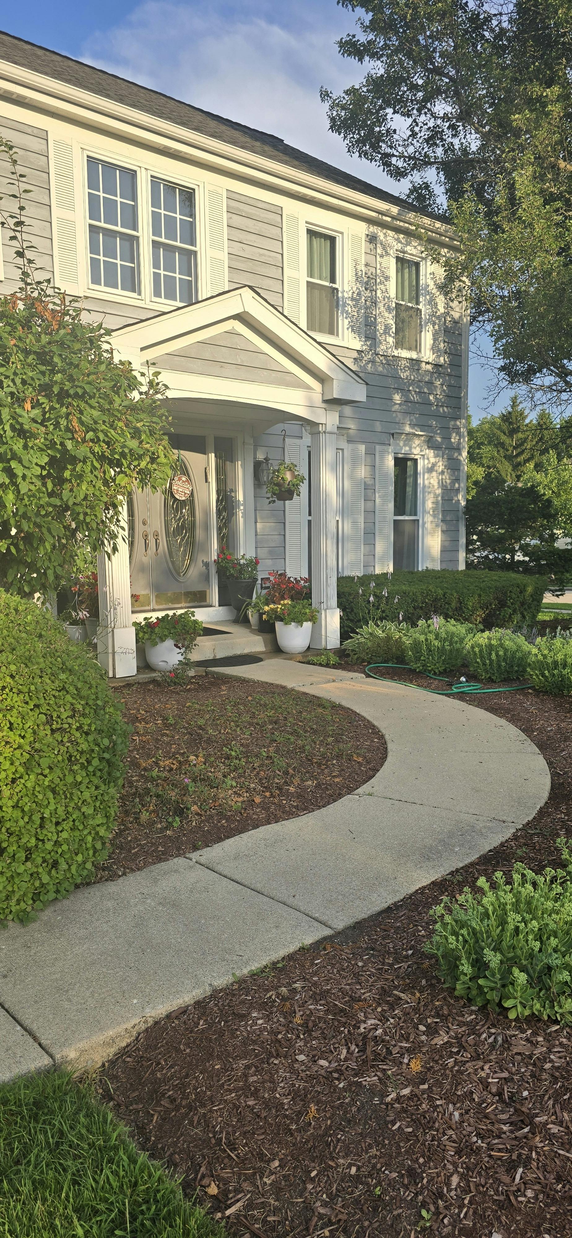 Front of a house with a curved sidewalk leading to the porch