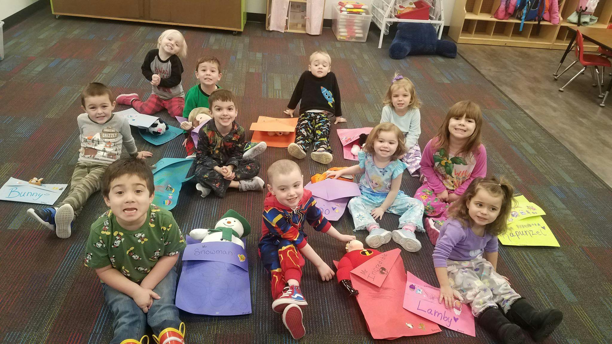 Group of children sitting on a floor with craft supplies