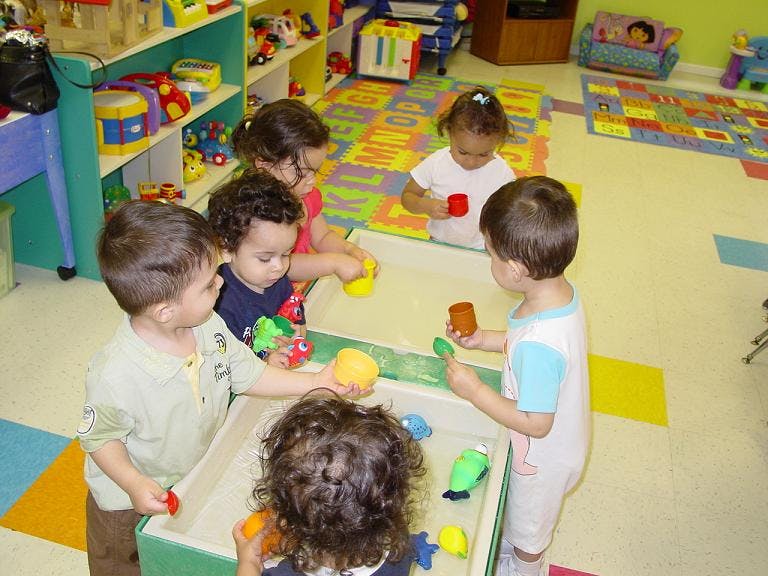 Children playing with toys in a water table