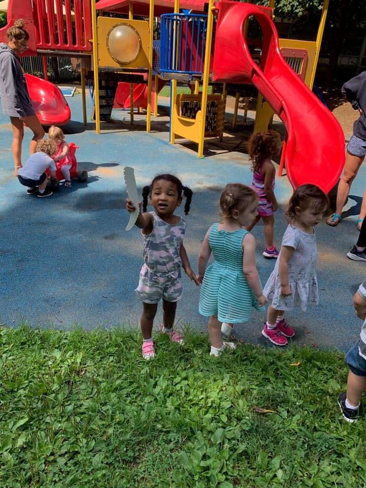 Children playing on a playground with a slide and play structure