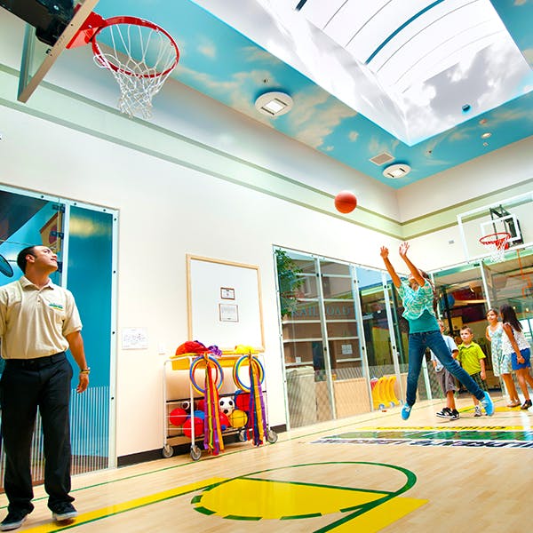 Person jumping to shoot a basketball in an indoor court