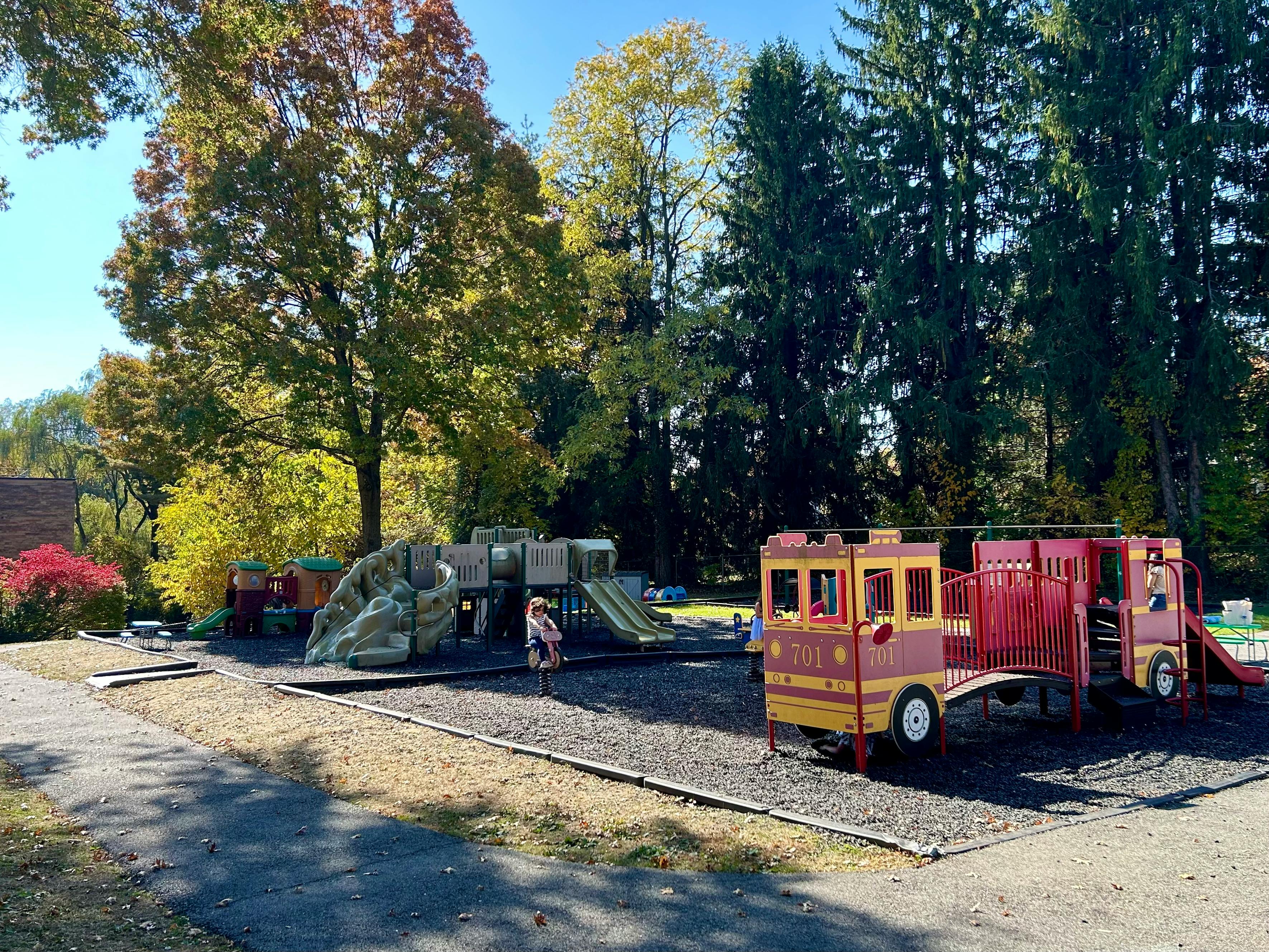 Child on a playground with a fire truck play structure