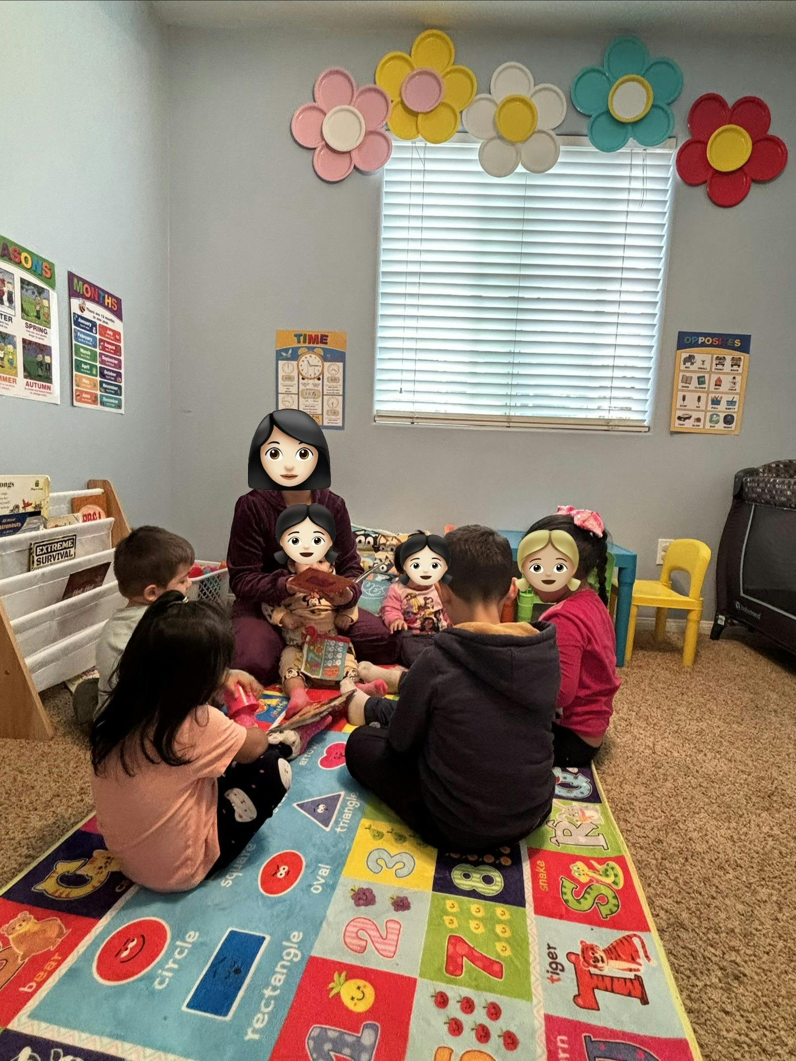 A person sitting with four children on a colorful mat with shapes and numbers