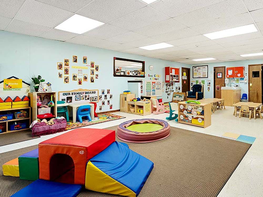 A classroom with child-sized furniture and colorful play equipment