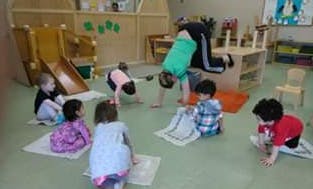 Adult and children doing yoga in a classroom