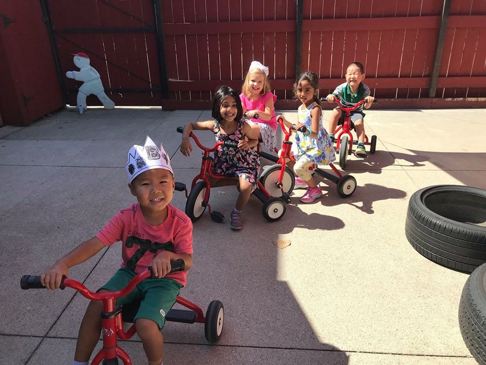 Children riding tricycles outdoors