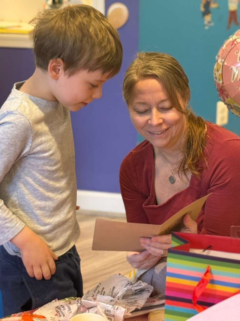 Child and person reading a card together