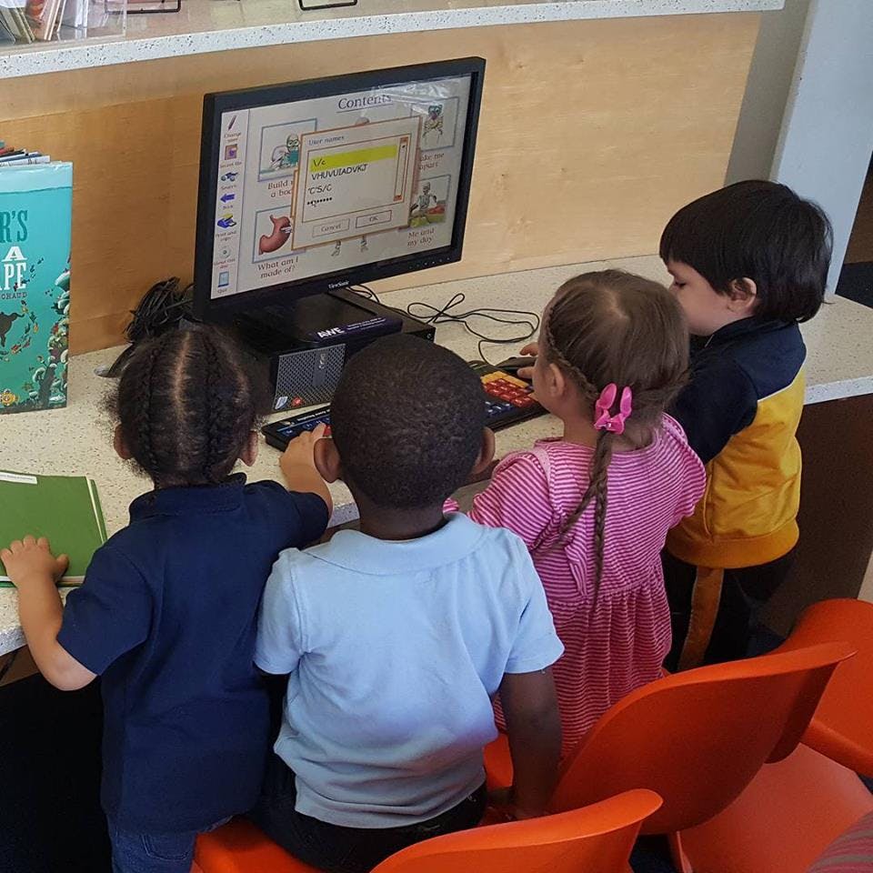 Four children looking at a computer screen