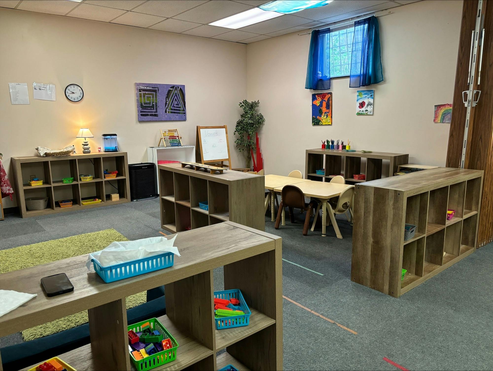 Classroom with tables, chairs, and shelves