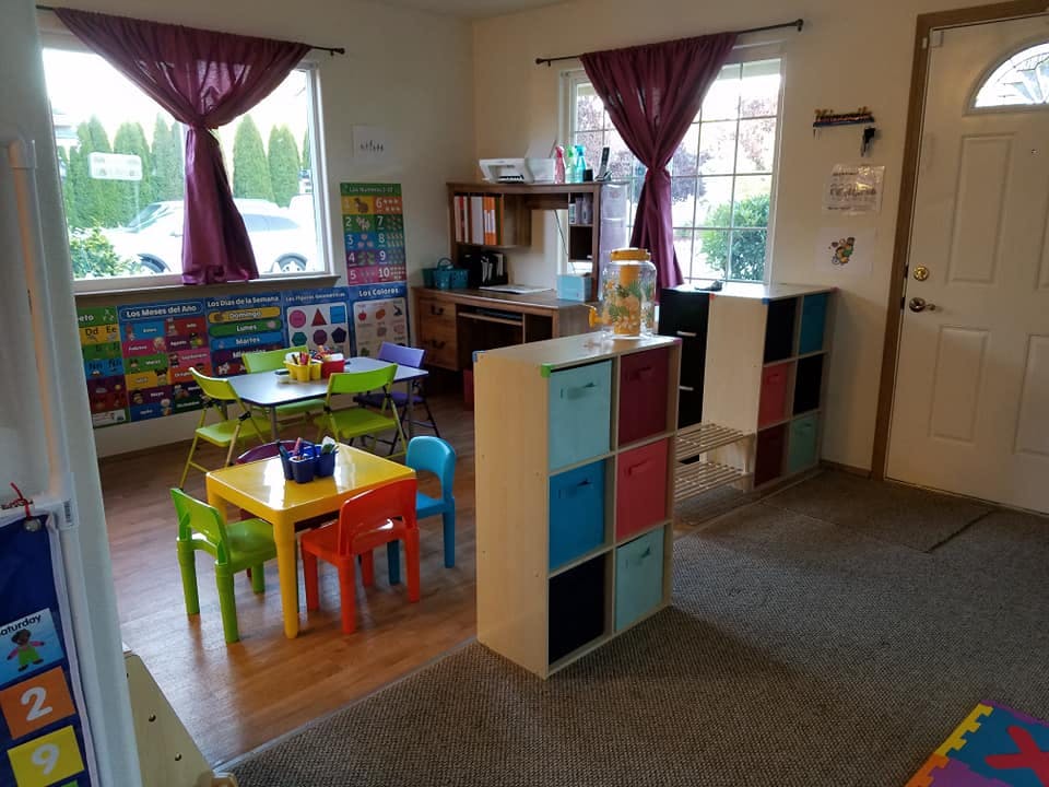 Classroom with small tables and chairs, storage units, and windows