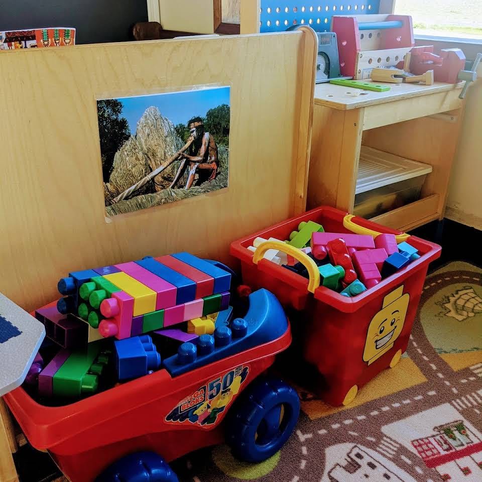 Toy wagon and bin filled with colorful building blocks in a room