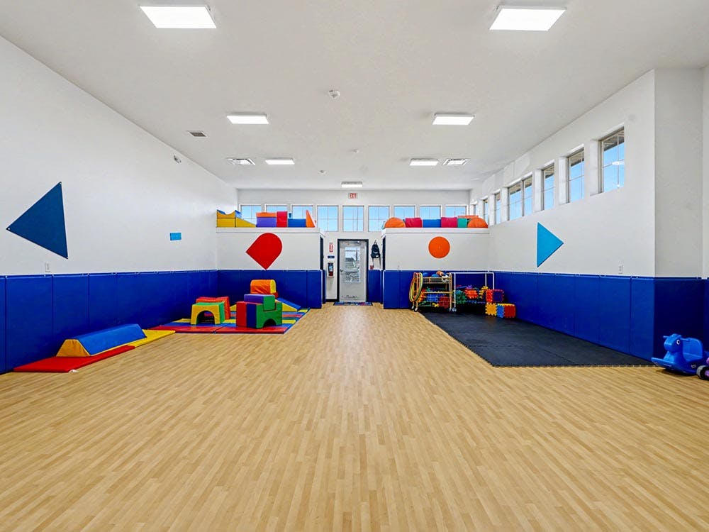 Indoor play area with soft colorful play equipment on mats