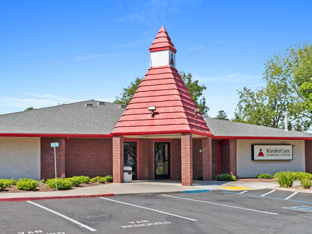 KinderCare Learning Center with a red-roofed entry tower and brick facade