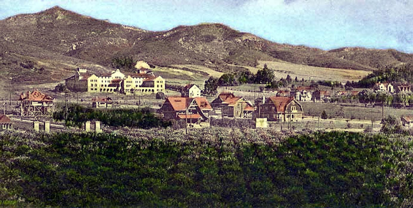 Buildings on a hillside with mountains in the background
