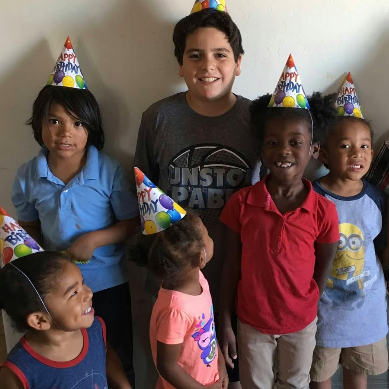 Group of children and teens wearing party hats