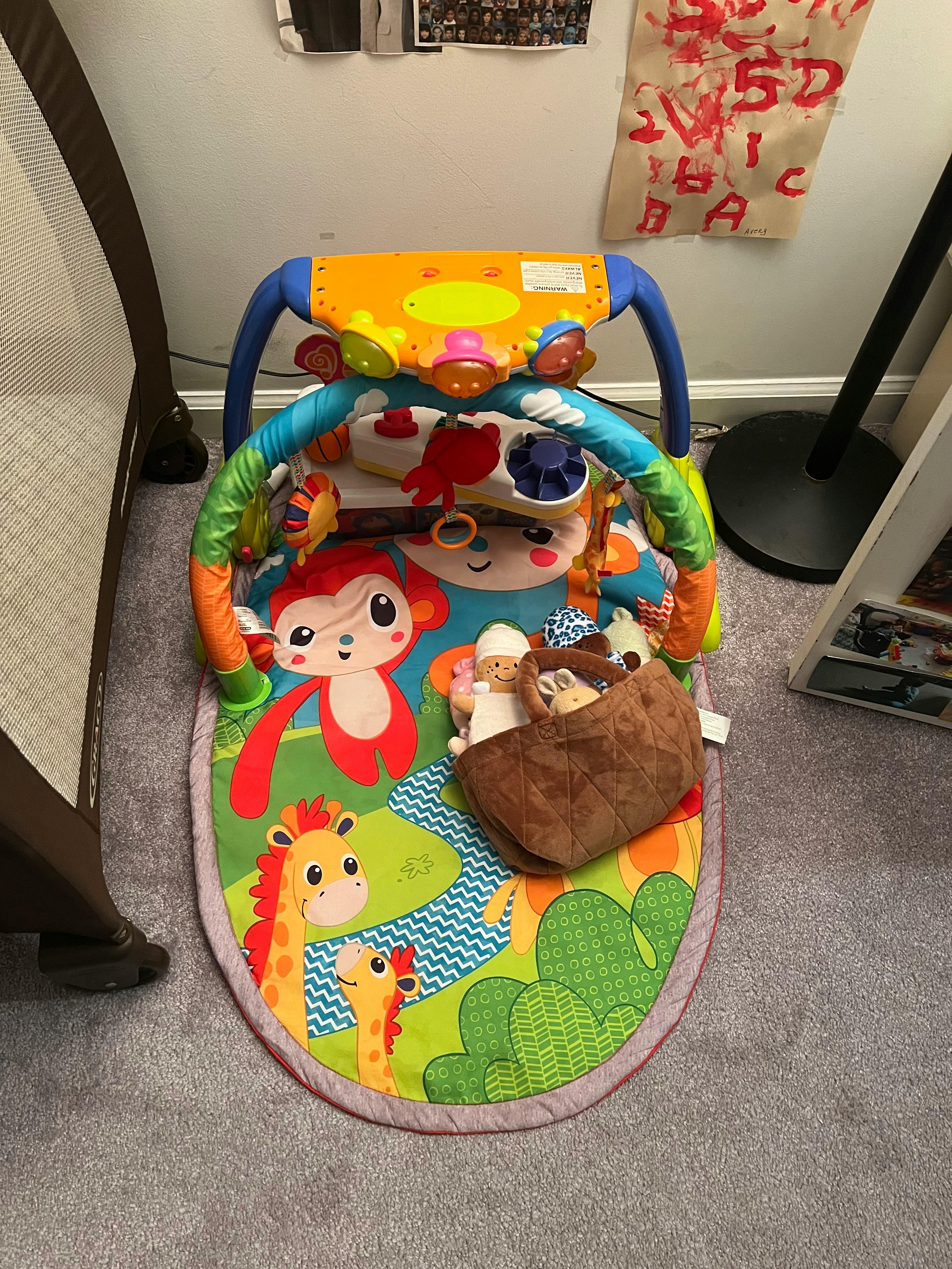 Baby play mat with colorful animal designs and hanging toys