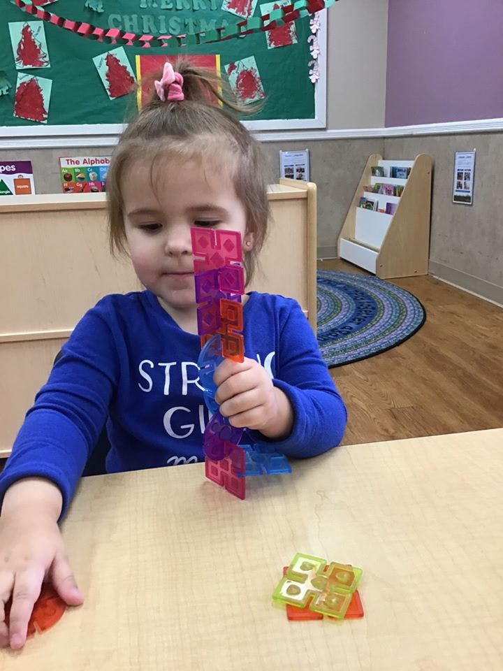 Child playing with colorful building blocks at a table