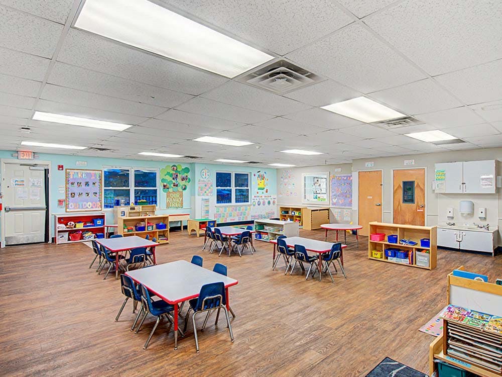 empty preschool classroom with small tables and chairs