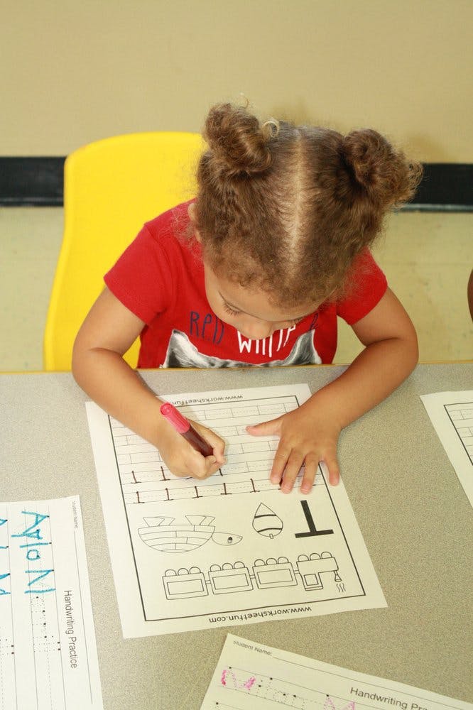 Child writing on a worksheet at a table