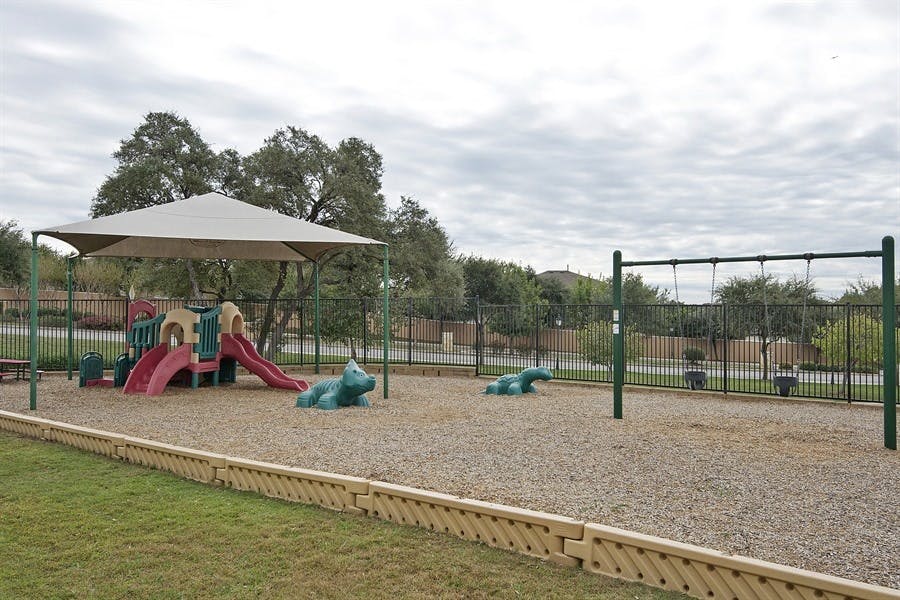 Playground with slides, swings, and a shade structure