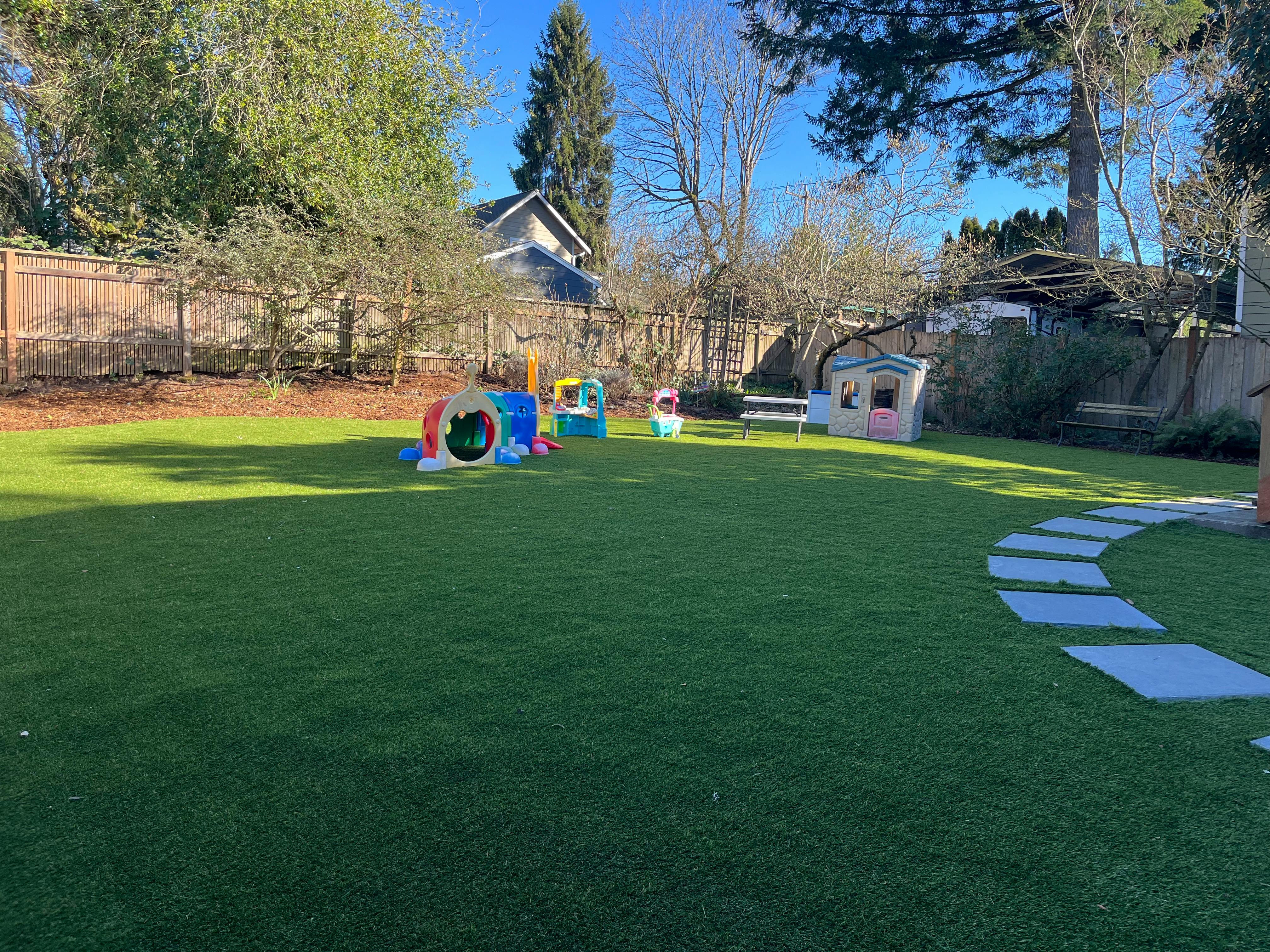 Backyard with green grass and children's play structures