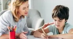 Adult and child writing at a table