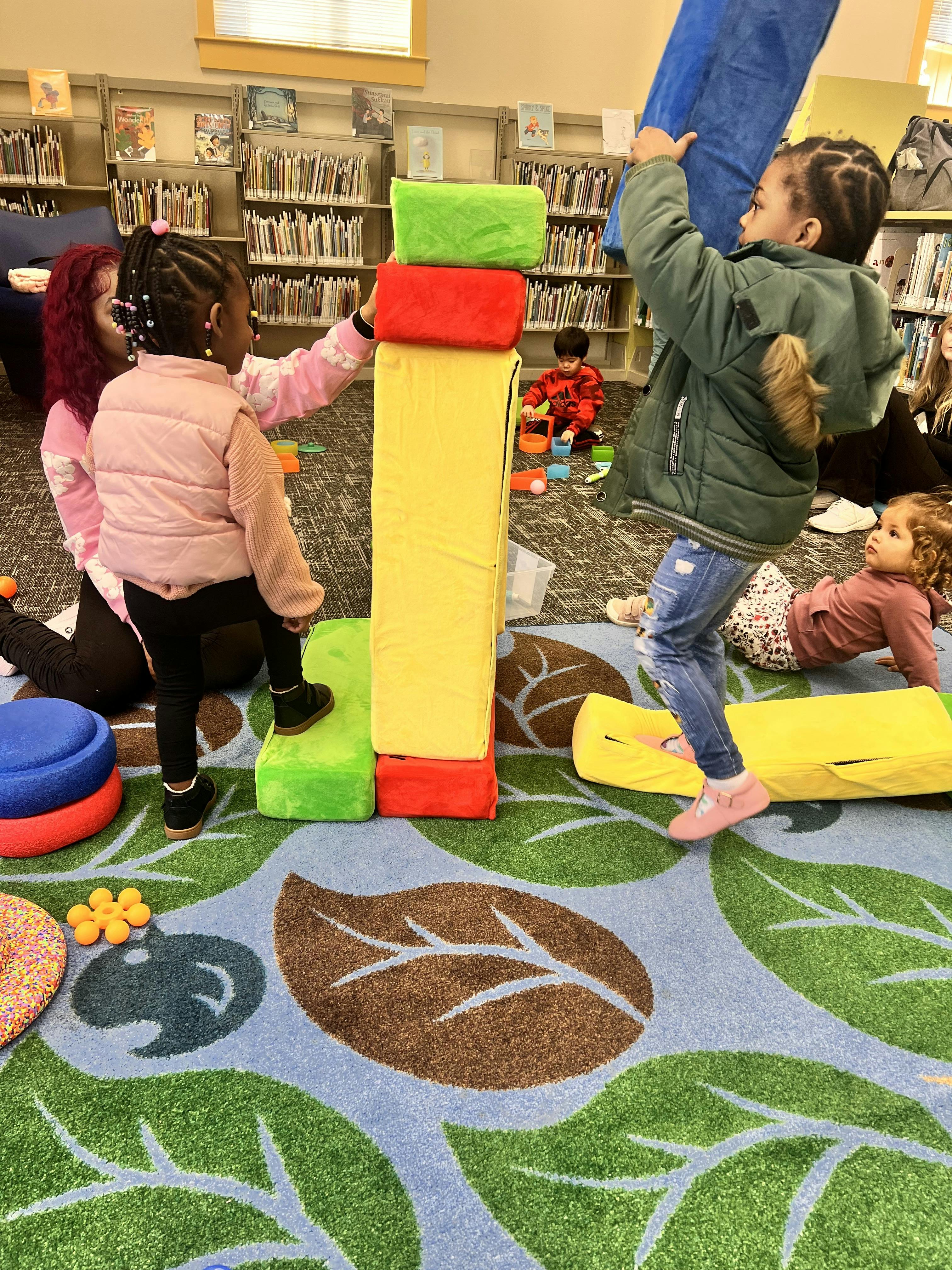 Children playing with large soft blocks in a library