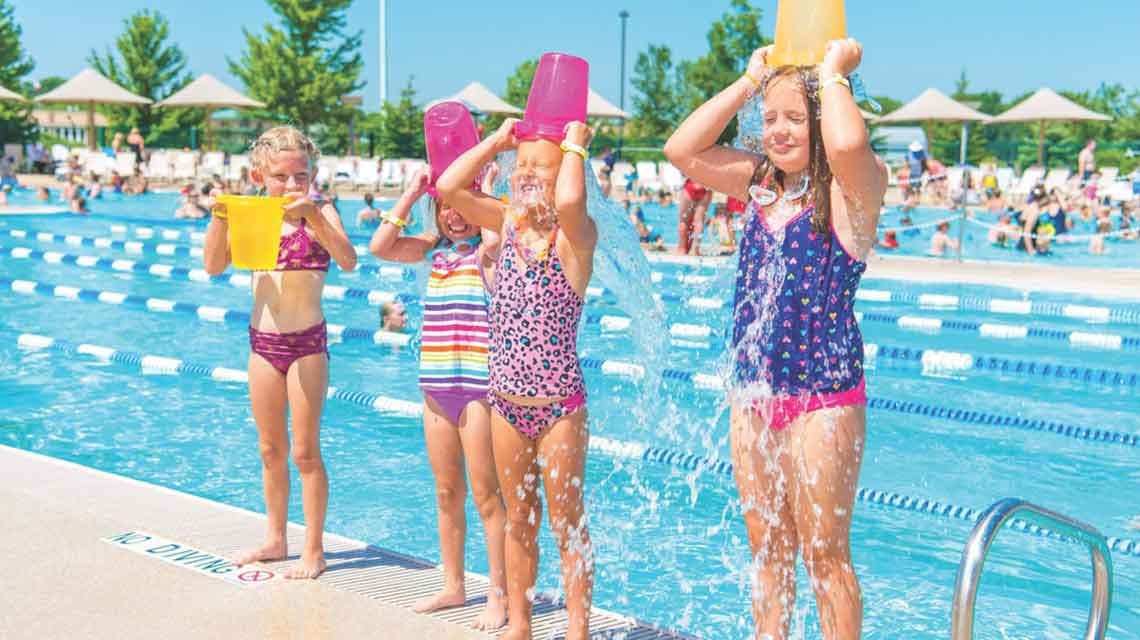 Children pouring water over their heads at a swimming pool
