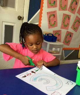 Child cutting paper with scissors