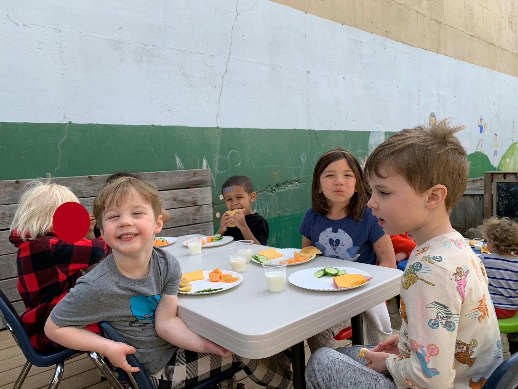 Children eating at a table outdoors