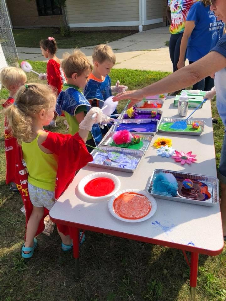 Children at a table with art supplies and paint