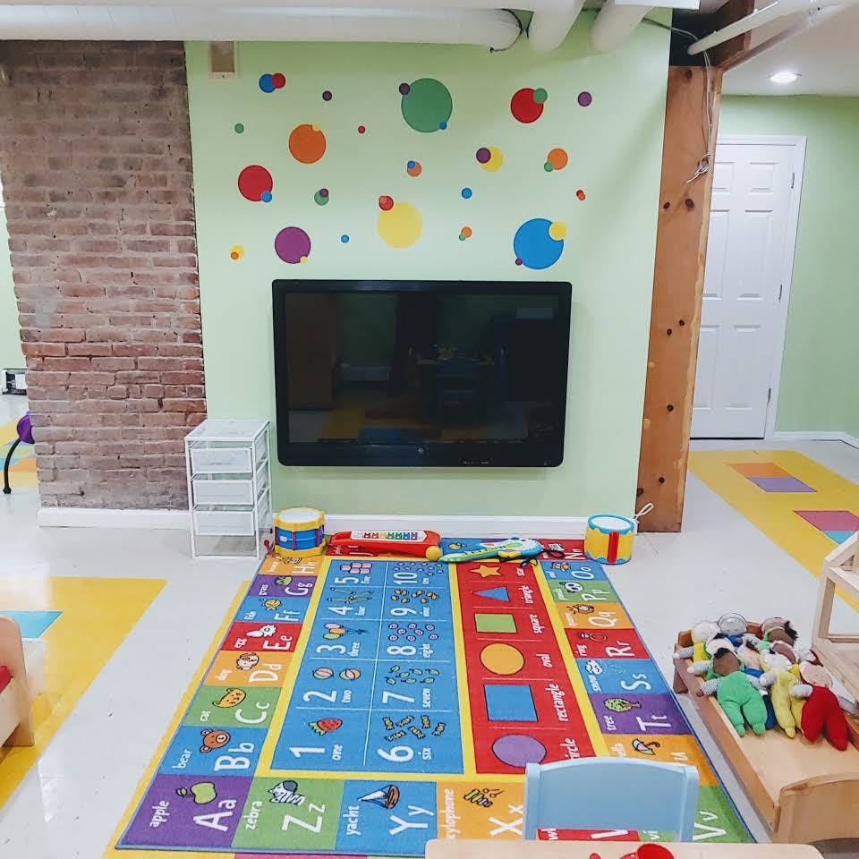 Playroom with a colorful alphabet rug and a television on the wall