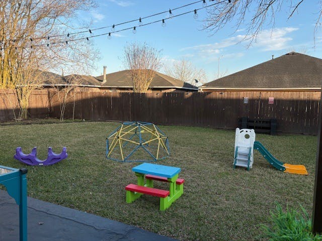 backyard with a slide, seesaw, geodesic dome, and picnic table on grass