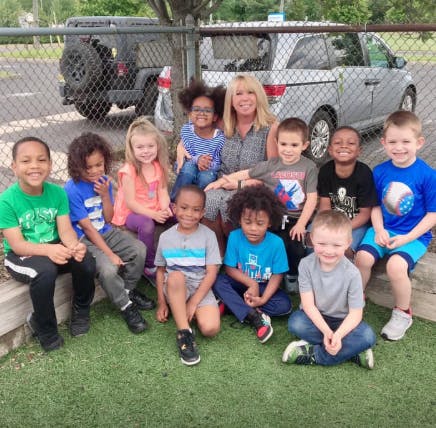 Adult and multiple children sitting together outdoors