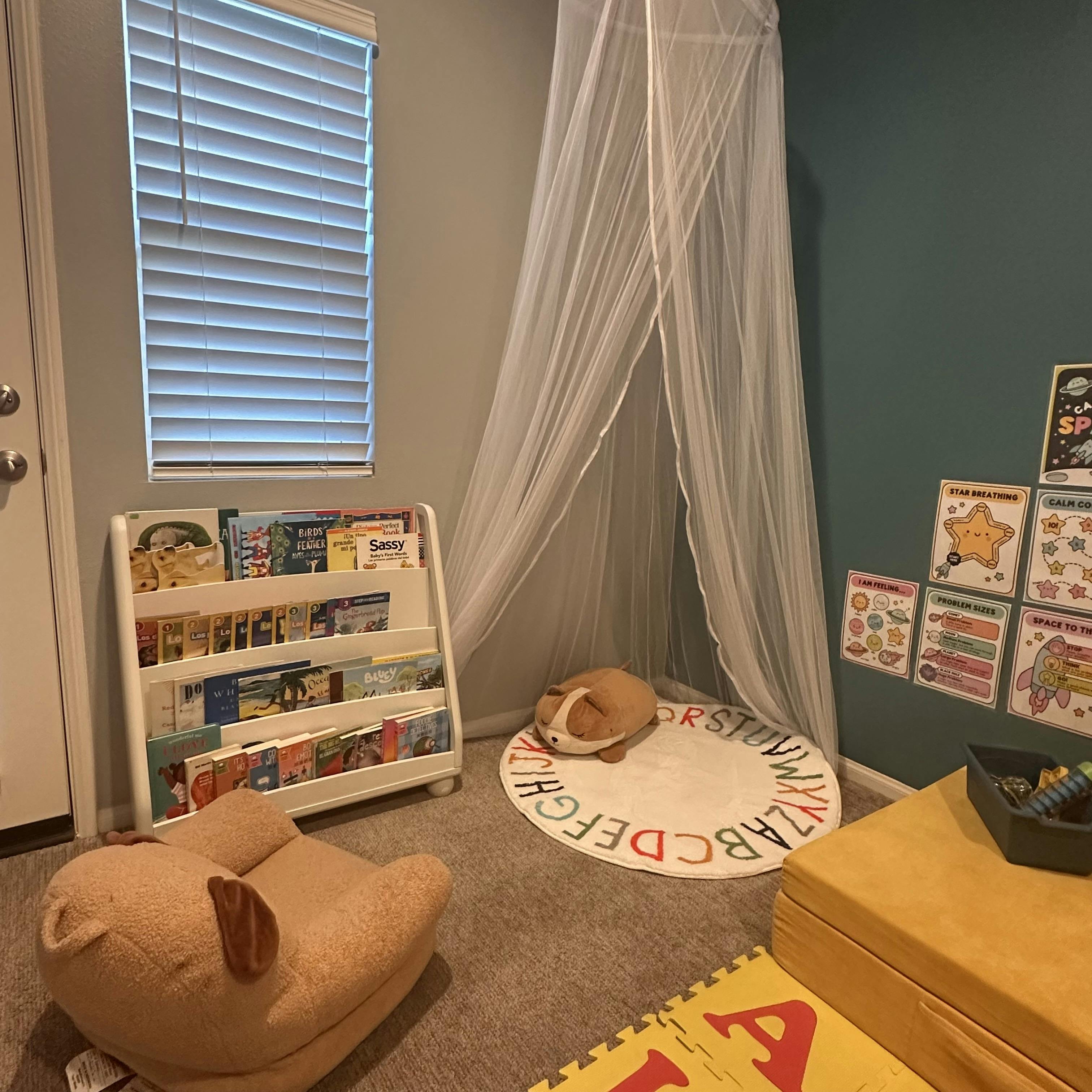 Reading corner with a book rack, canopy, alphabet rug, and plush seating