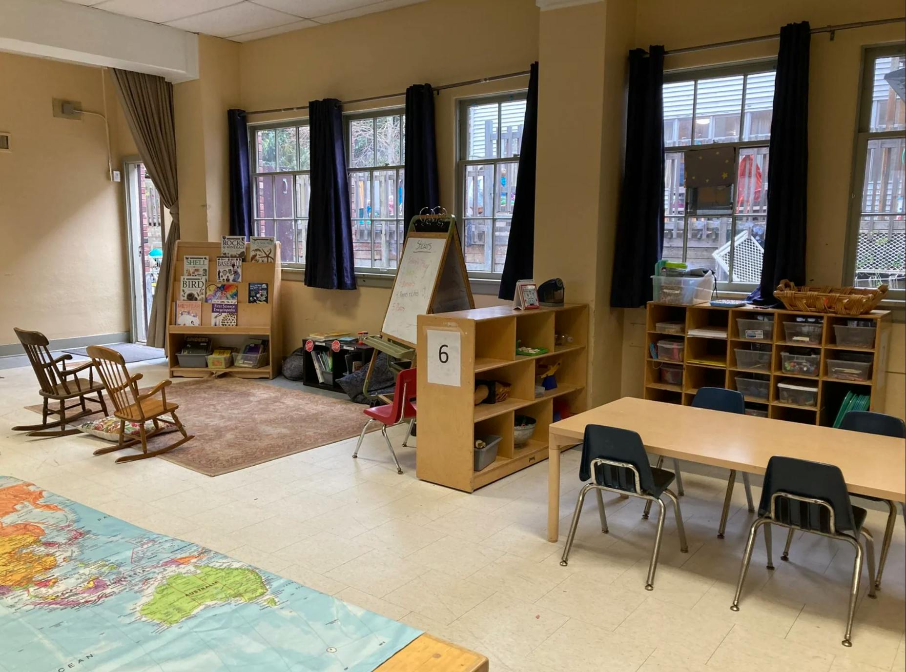 Classroom interior with small tables chairs and shelves for books and toys