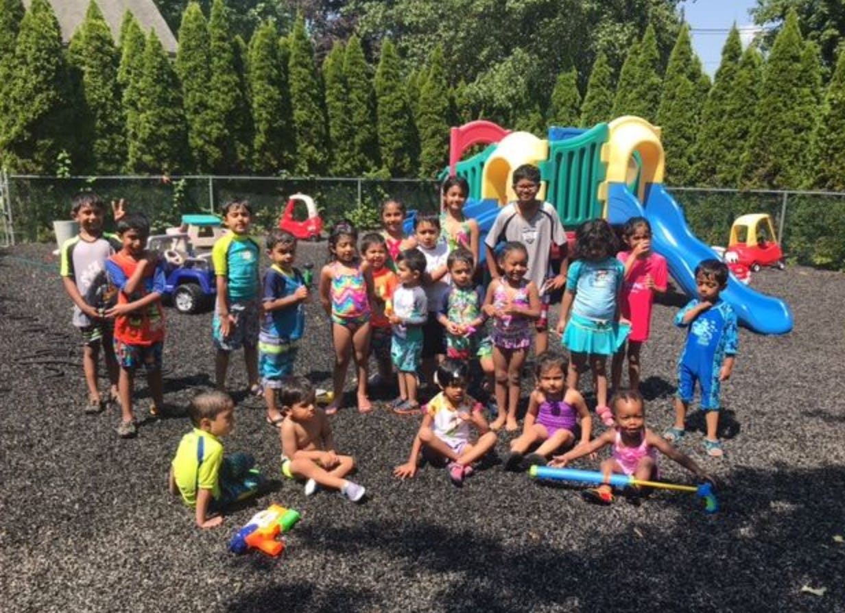 Group of children and adults in swimwear on a playground