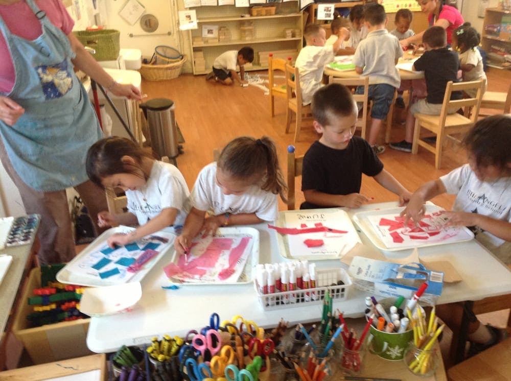 Children doing art projects at tables in a classroom