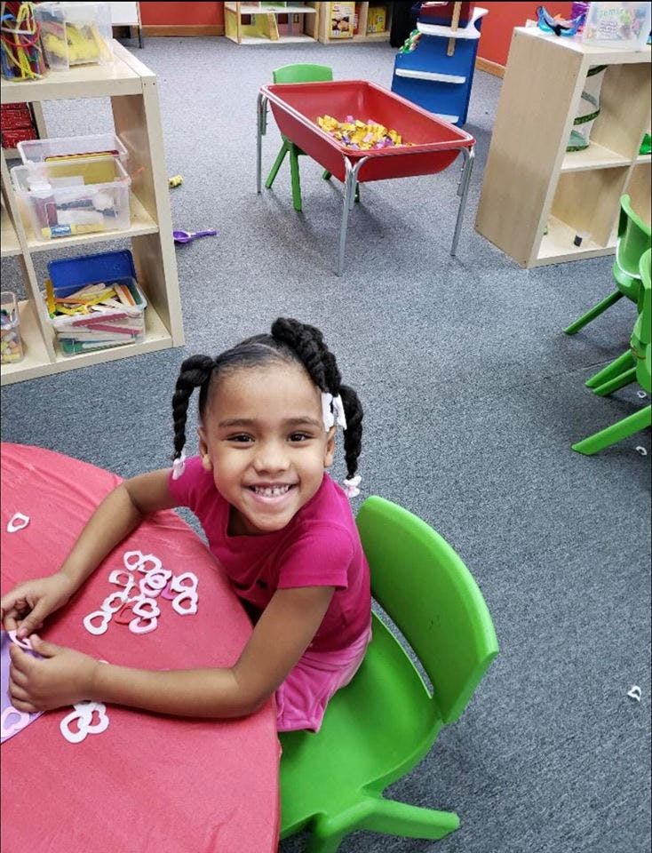 Child sitting at a table with cut-out letters