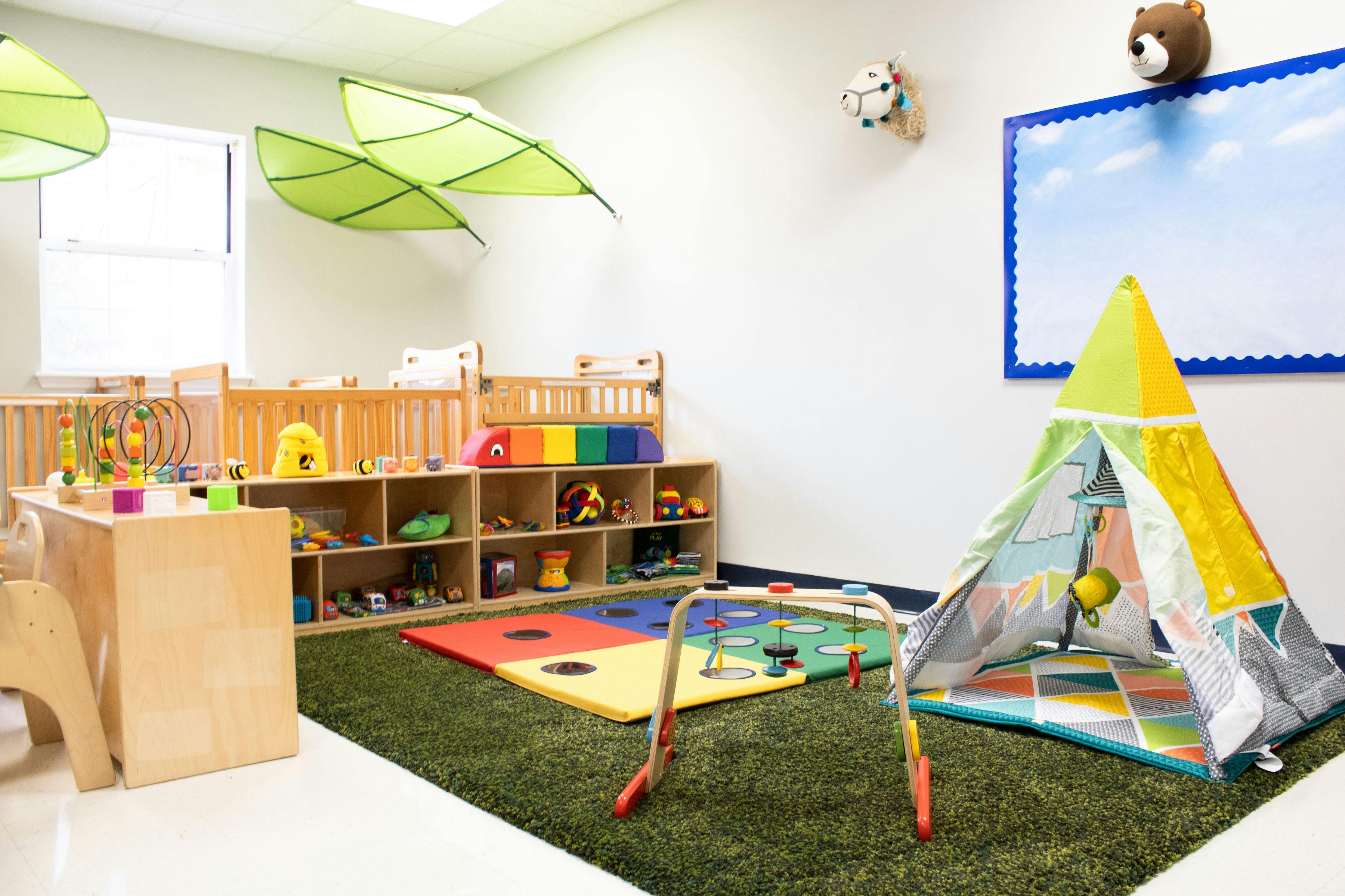 Playroom with a teepee, playmat, and shelves of toys