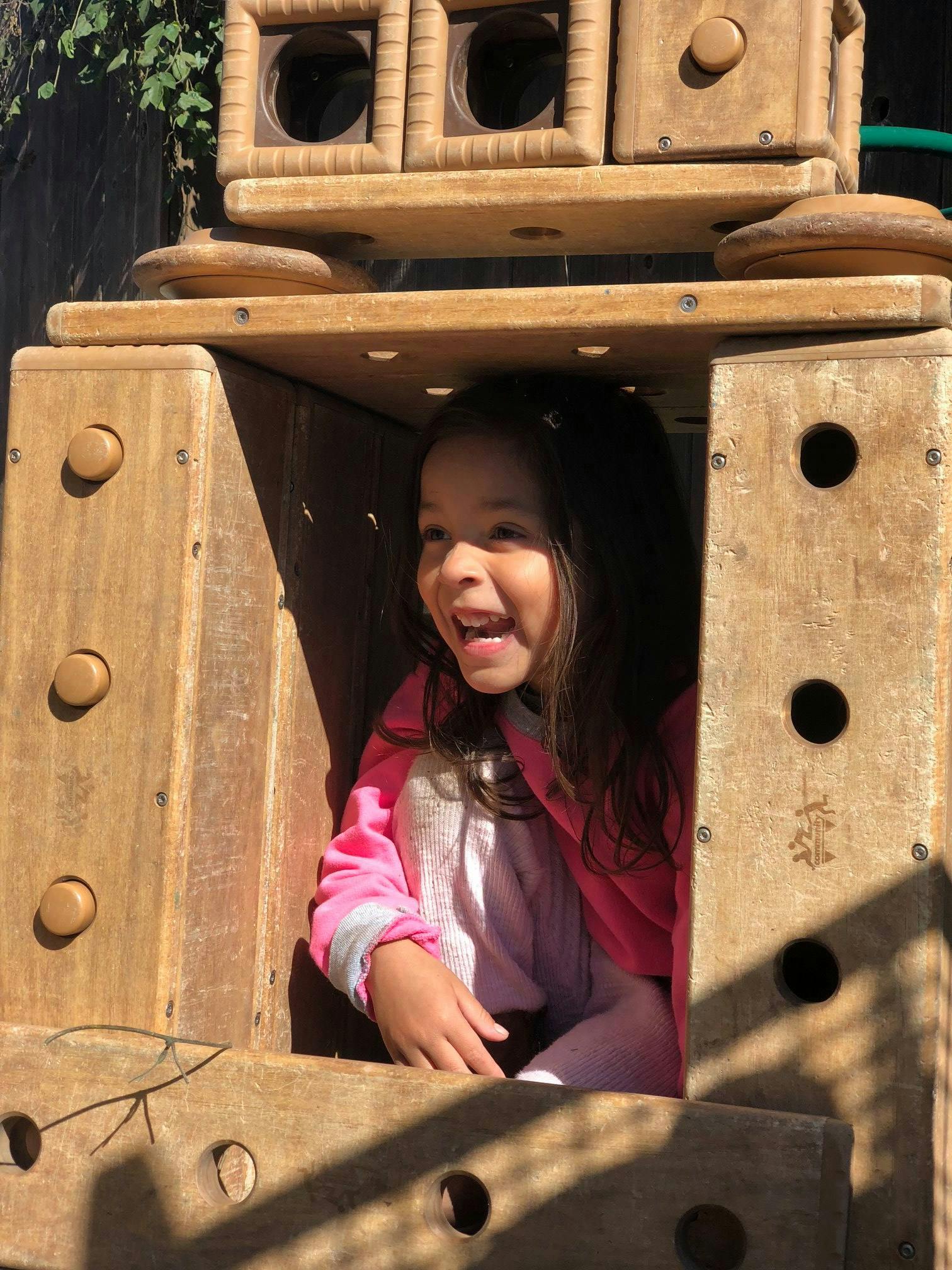 Child in a wooden play structure