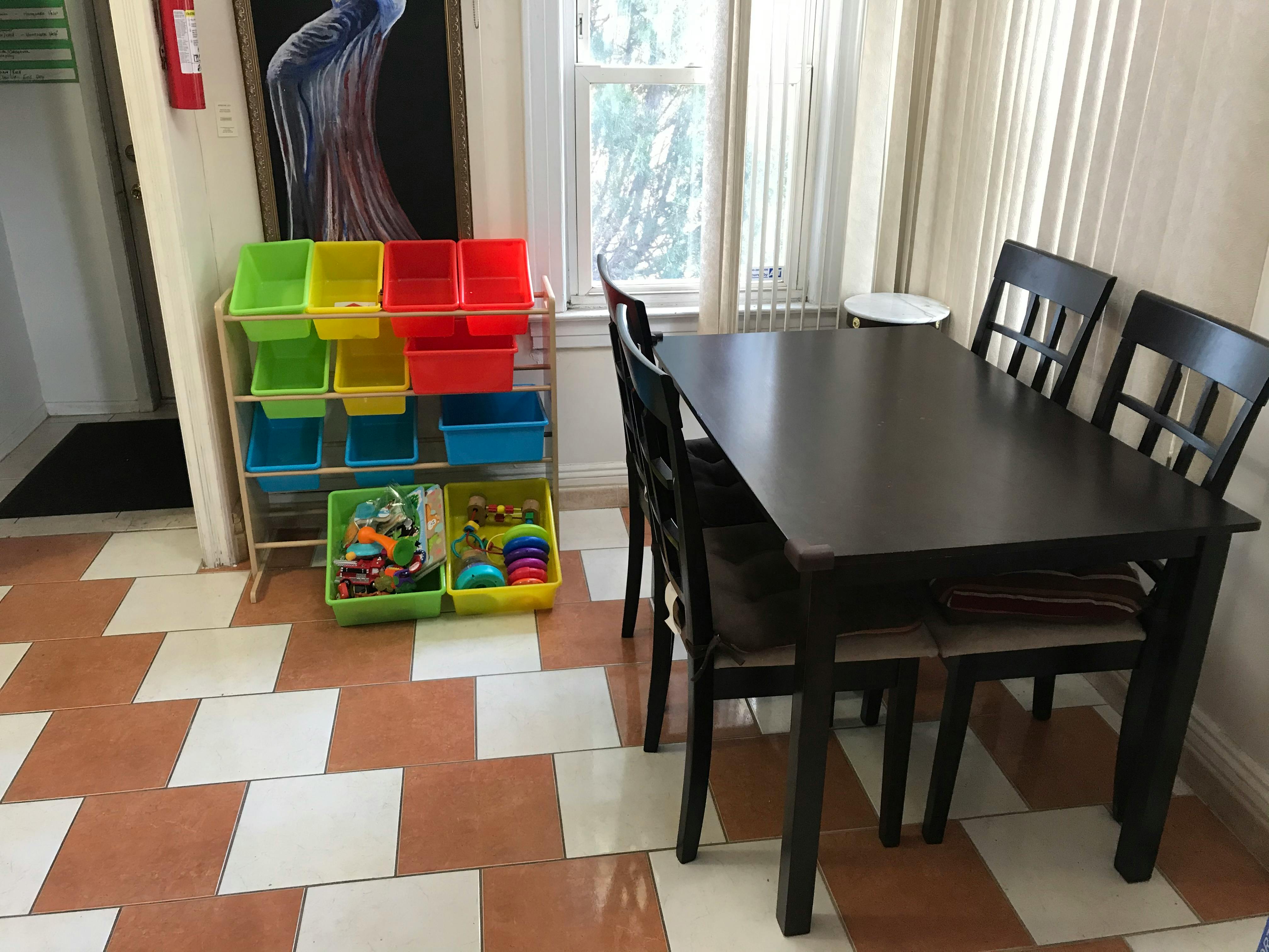 Dining table with chairs and a toy organizer with colorful bins
