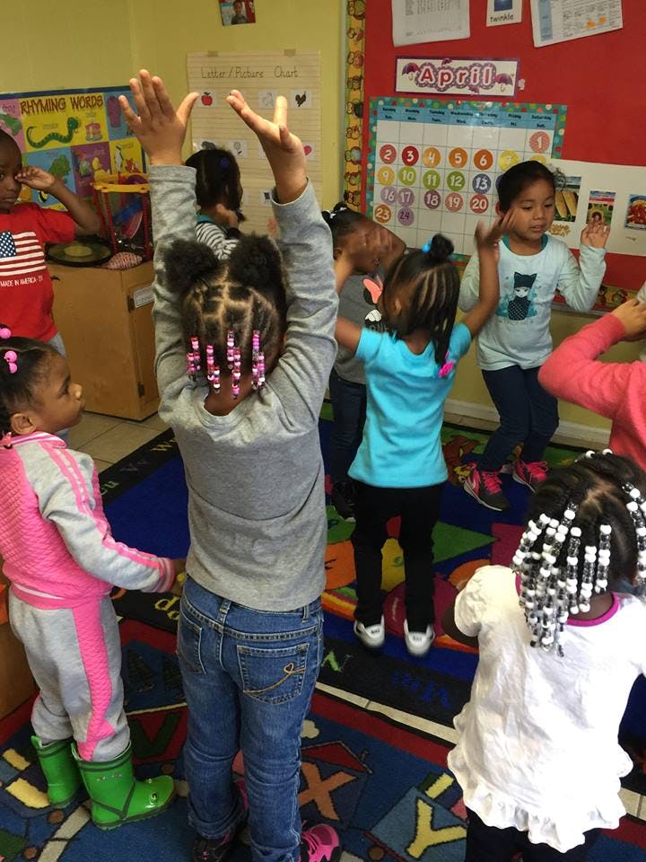 Children raising their hands in a classroom