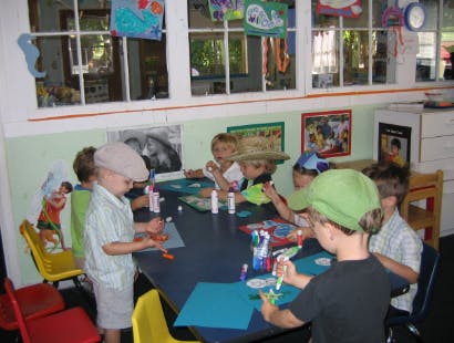 Children doing crafts at a table in a classroom