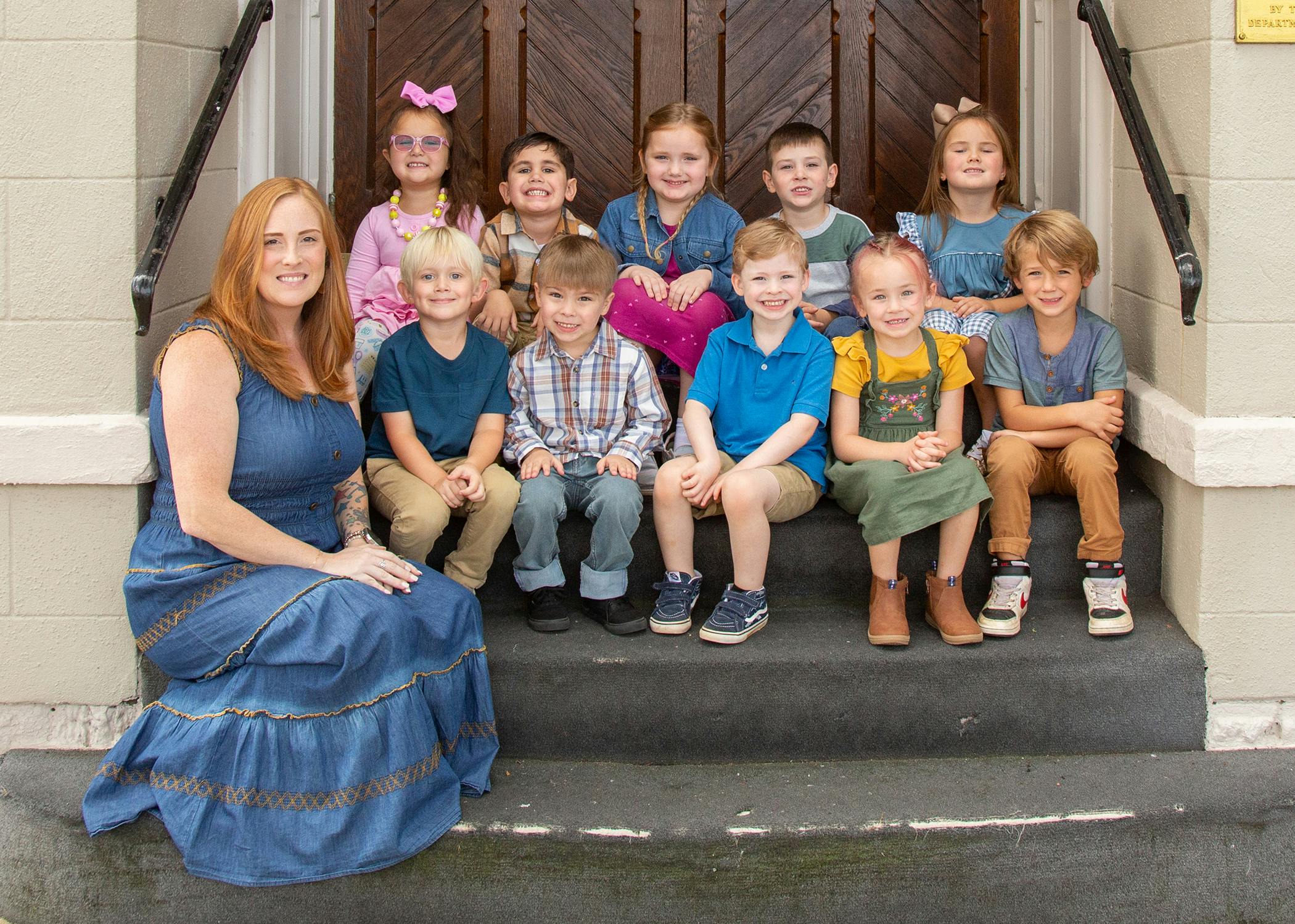 Adult and group of children sitting on steps